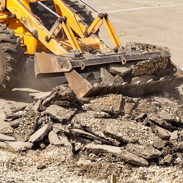 Yellow Excavator Dig the Asphalt with Tractor Bucket. Bulldozer Dismantles Asphalt at Work